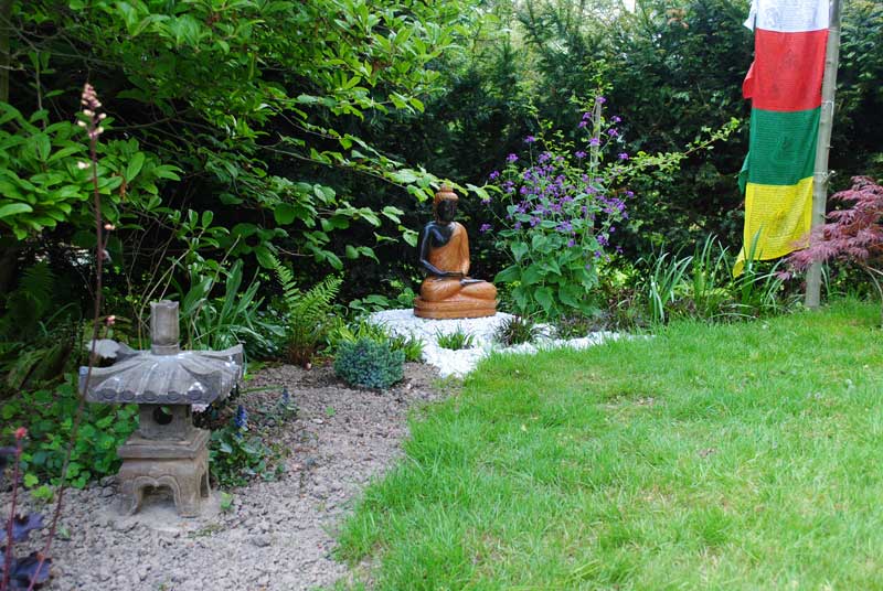 Buddha Figur im blühenden Garten