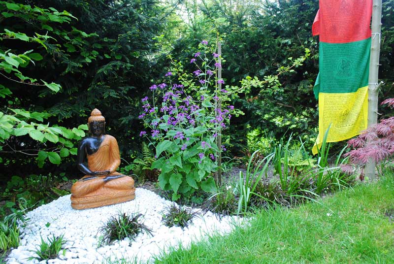 Buddha Figur im blühenden Garten